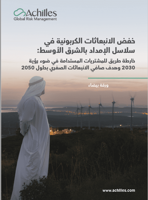 رجل يقف متأملاً مزرعة رياح في الصحراء عند غروب الشمس