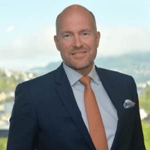 Head and shoulder shot of Odfjell’s Chief Sustainability Officer Øistein Jensen wearing navy suit, light blue shirt and reddish colour tie. 