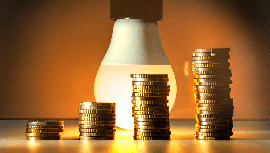 stacks of coins next to a light bulb